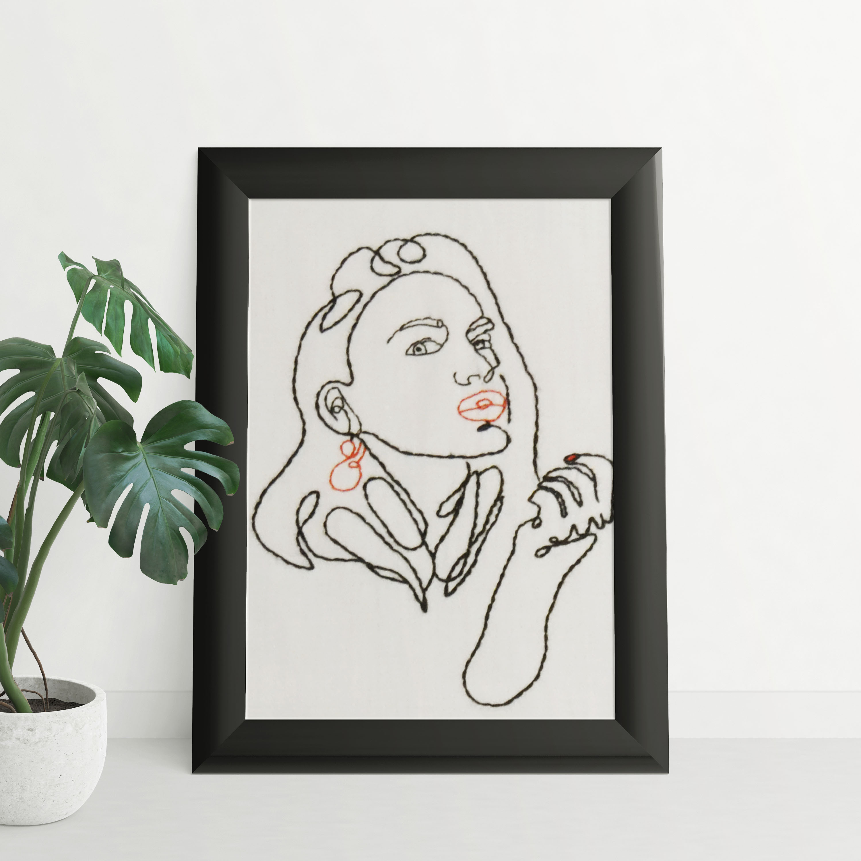Portrait féminin brodé avec des accents rouges